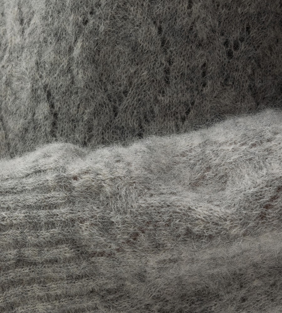 Kvinna och man går längst med strandkanten och bär linneplagg