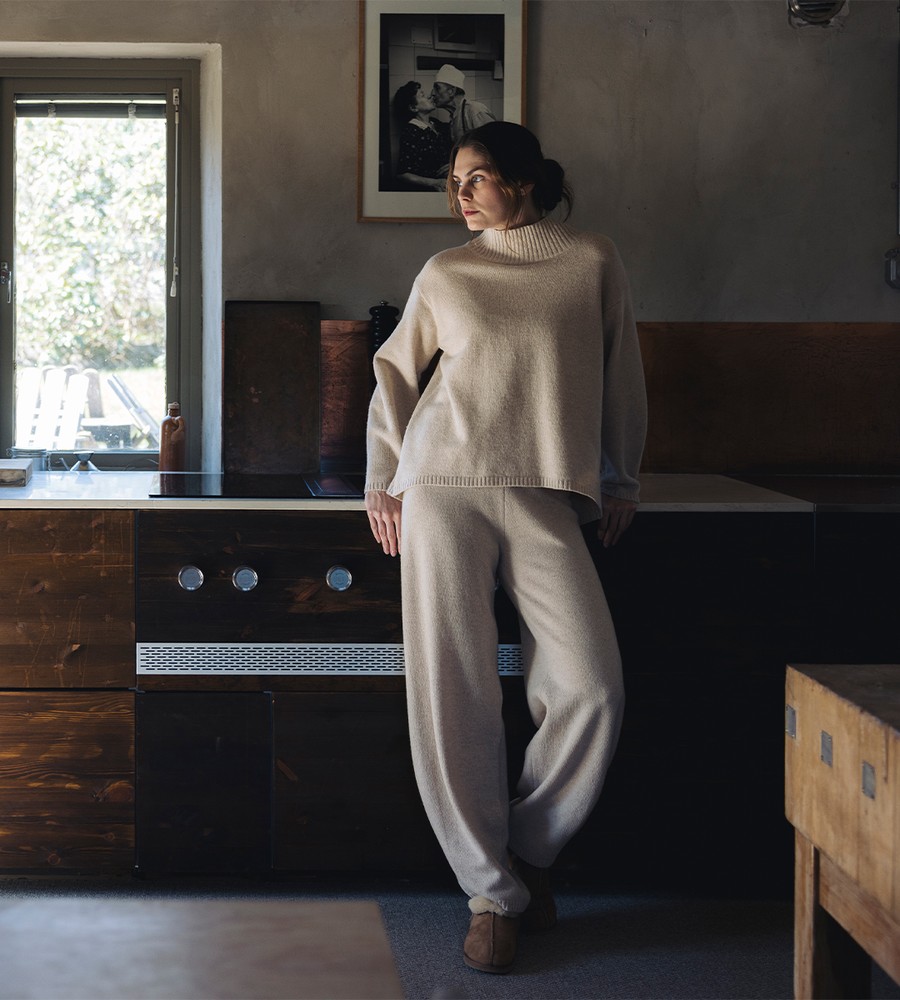 Flera stickade plagg som hänger på galge på en klädställning