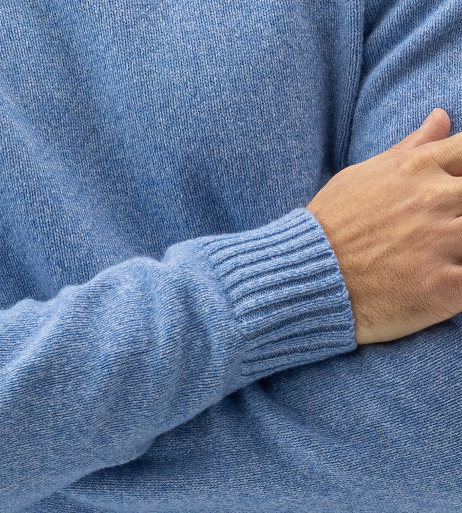Kvinna och man går längst med strandkanten och bär linneplagg