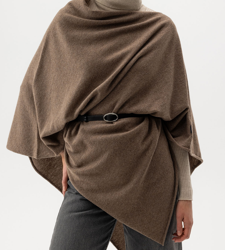 Flera stickade plagg som hänger på galge på en klädställning