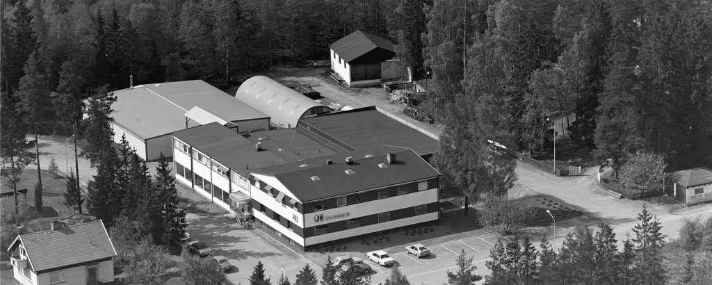 1964 invigdes huskroppen till vänster i bild med entrén. Flygbilden är från 1976 och här har fastigheten expanderat ytterligare.