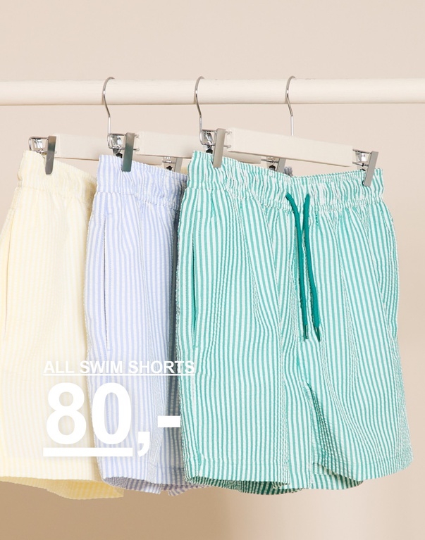Tre stribede badeshorts på bøjler i gul, lyseblå og grøn. ALLE BADESHORTS 80,-