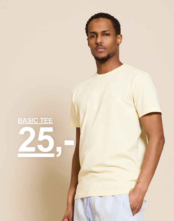 Mand i lysegul t-shirt og stribede shorts. BASIC T-SHIRT 25,-