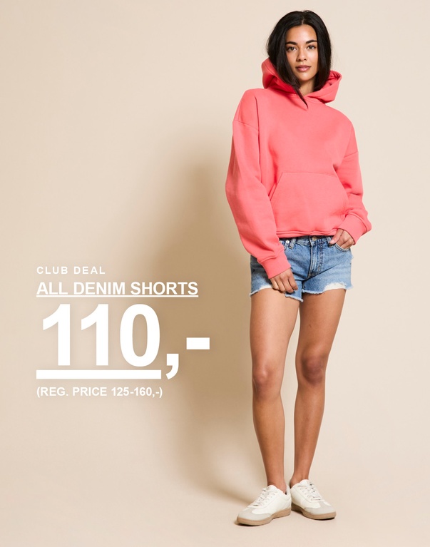 Pige i denimshorts og koralfarvet hoodie. Kampagnetekst: "CLUB DEAL, DENIMSHORTS, 70,- (NORMALPRIS 125,-)".