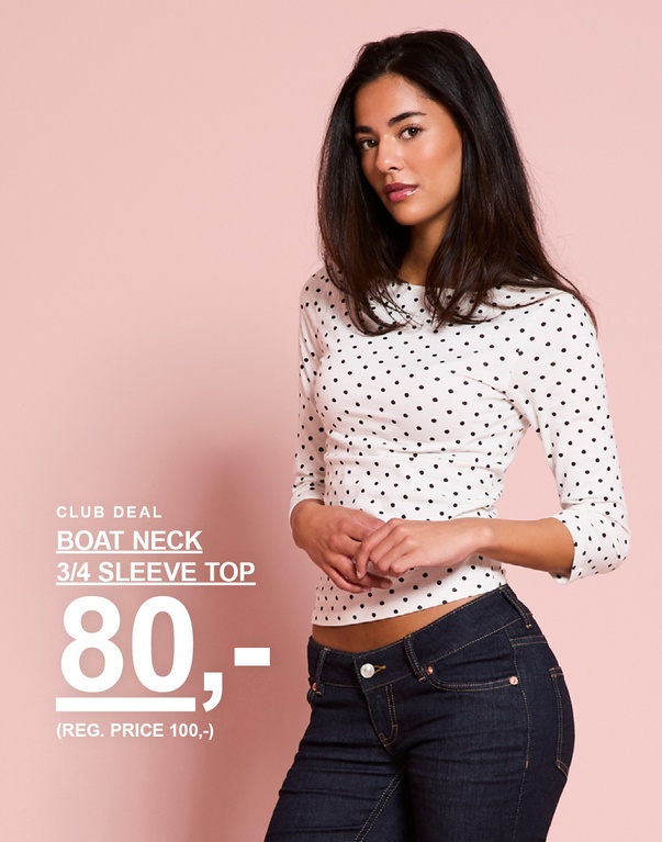 Model har en hvid prikket top med trekvartærmer og bådudskæring på. CLUB DEAL – BOAT NECK 3/4 SLEEVE TOP 80,- (REG. PRICE 100,-).
