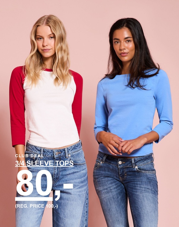 To piger i toppe med 3/4-ærmer, en hvid med røde ærmer og en blå. Kampagnetekst: ”3/4 SLEEVE TOPS 80,- (NORMALPRIS 100,-)”