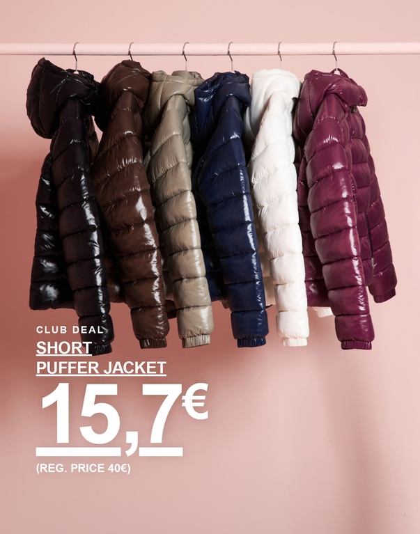 Mehrere kurze Steppjacken in verschiedenen Farben hängen auf Kleiderbügeln. CLUB DEAL – SHORT PUFFER JACKET 15,7€ (REG. PRICE 40€).