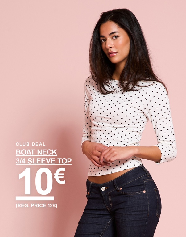 Model trägt ein weißes gepunktetes Oberteil mit Dreiviertelärmeln und U-Boot-Ausschnitt. CLUB DEAL – BOAT NECK 3/4 SLEEVE TOP 10 € (REG. PRICE 12 €).