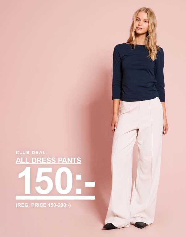 Modell bär marinblå topp och ljusa dressade byxor. CLUB DEAL – ALL DRESS PANTS 150:- (REG. PRICE 150–200:-).