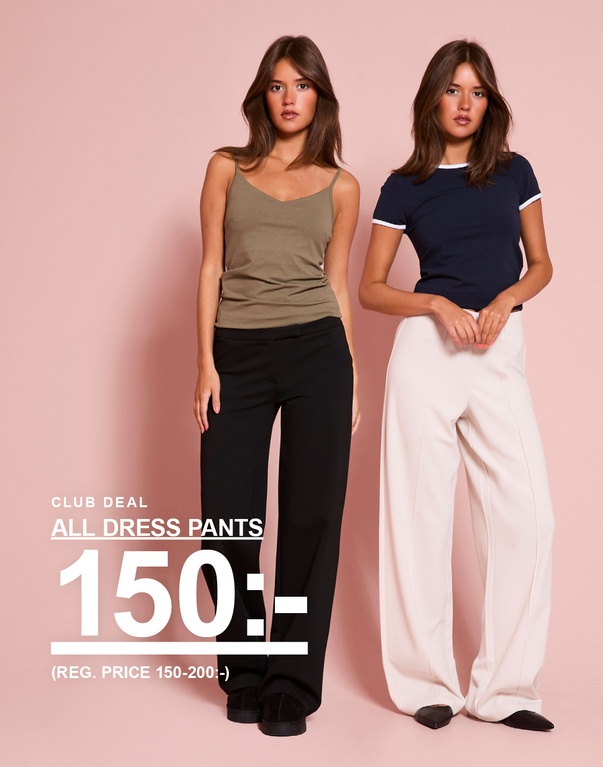 Tjej bär en beige topp och dressade byxor samt en marinblå t-shirt med vita detaljer och vita dressade byxor. CLUB DEAL – ALL DRESS PANTS 150:- (REG. PRICE 150–200:-).