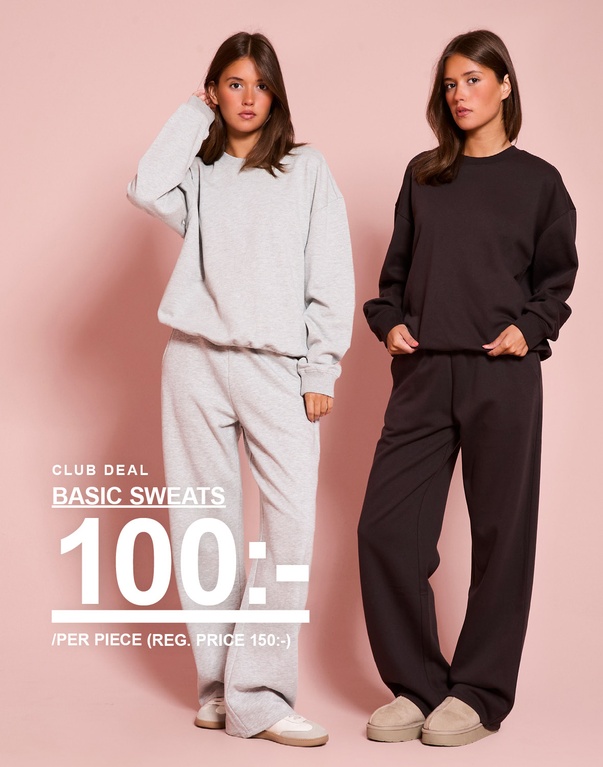 Två tjejer i matchande sweatshirts och sweatpants, ett set i grönt och ett i mörkbrunt. Kampanjtext: "CLUB DEAL, BASIC SWEATS, 100:- /PER PIECE (ORD. PRIS 150:-)".
