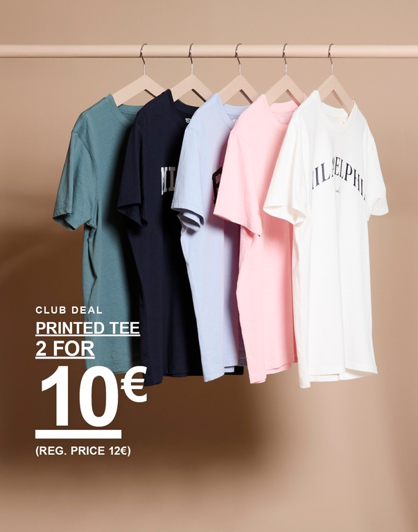 Mehrere T-Shirts mit Print in verschiedenen Farben auf Kleiderbügeln vor hellem Hintergrund. Kampagnentext: „CLUB DEAL PRINTED TEE 2 FOR 10€ (REG. PRICE 12€)“.