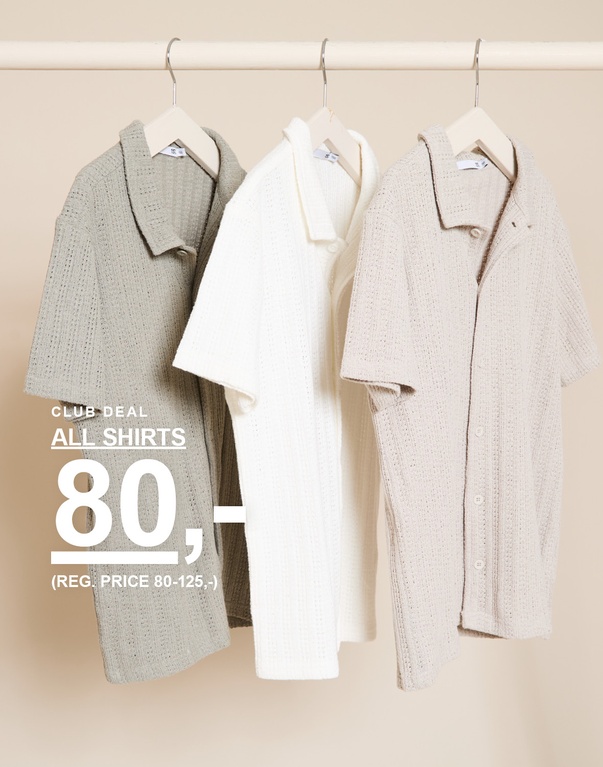 Tre strikkede kortærmede skjorter i farverne grøn, hvid og beige på bøjler foran en lys baggrund. CLUB DEAL ALL SHIRTS 80,- (REG. PRICE 80-125,-)