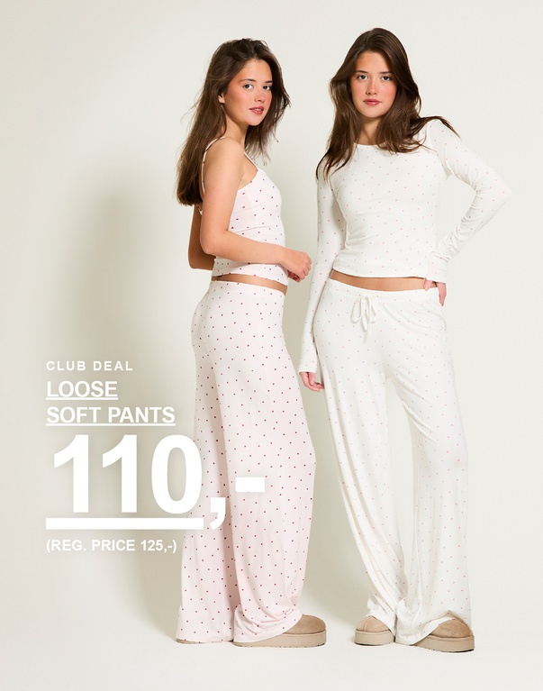 To piger i loose soft pants, én rosa med hjerter og én hvid med hjerter. Kampagnetekst: 'CLUB DEAL, LOOSE SOFT PANTS, 110,- (NORMALPRIS 125,-)'.