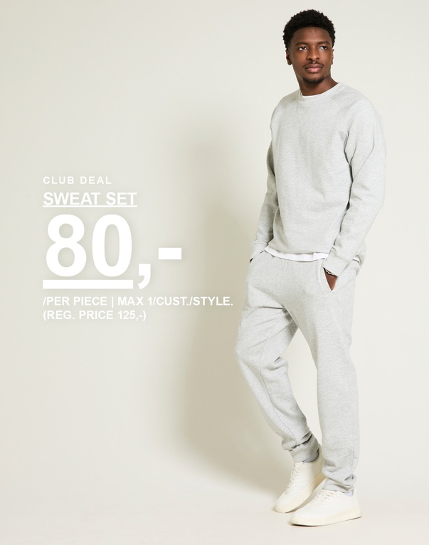 Mand i gråt sweat set med sweatshirt og sweatpants mod lys baggrund. Club deal sweat set 80,- /per piece | max 1/cust./style. (reg. price 125,-)