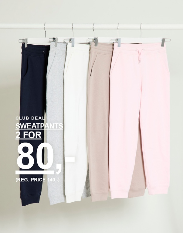 Sweatpants i navy, grå, offwhite, beige og rosa hængende på bøjler mod lys baggrund. CLUB DEAL SWEATPANTS 2 FOR 80,- (REG. PRICE 140,-)