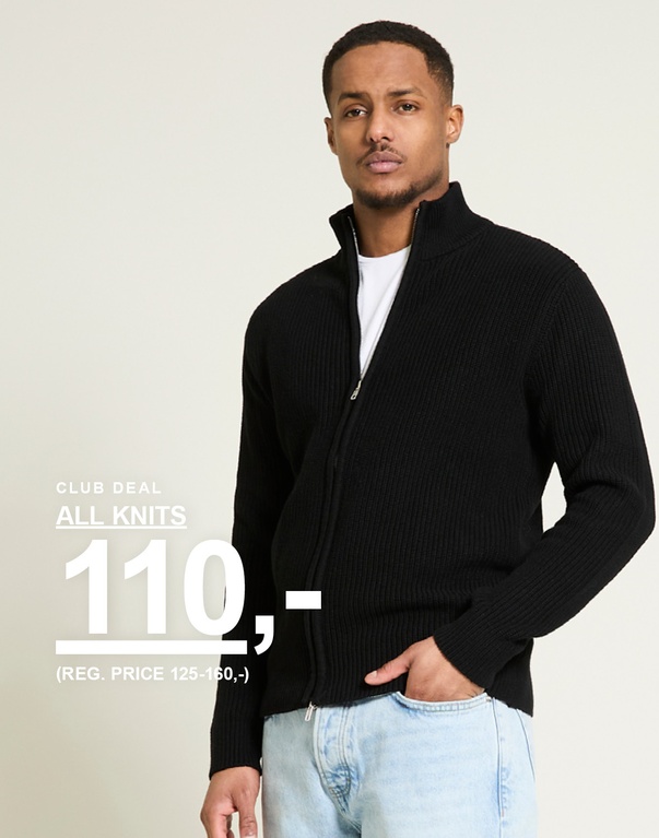 Mand i sort ribstrikket cardigan med lynlås og lyse jeans mod lys baggrund. Club deal all knits 110,- (reg. price 125-160,-)