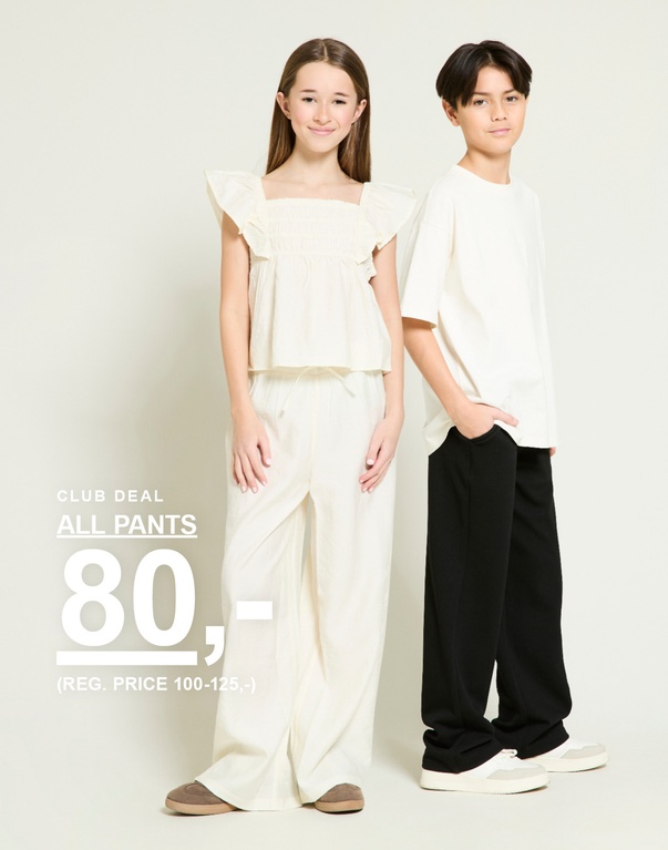 To børn i lyse overdele og bukser i beige og sort. Kampagnetekst: “ALL PANTS, 80,-”