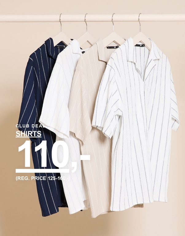 Stribede kortærmede skjorter i blå, hvid og beige hænger på bøjler foran beige baggrund. CLUB DEAL. SHIRTS 110,- (REG. PRICE 125–160,-)
