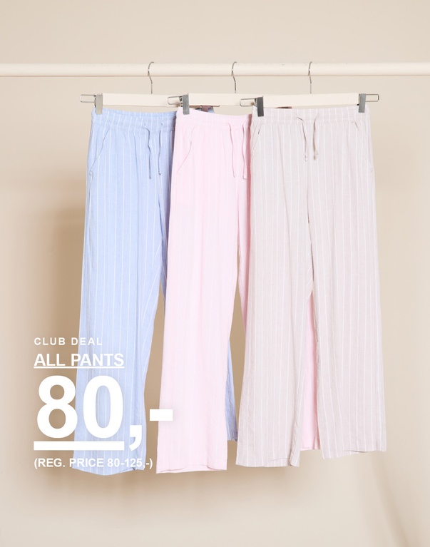 Tre stribede bukser i lyseblå, lyserød og beige hænger på bøjler foran en lys baggrund. CLUB DEAL ALL PANTS 80,- (REG. PRICE 80-125,-)