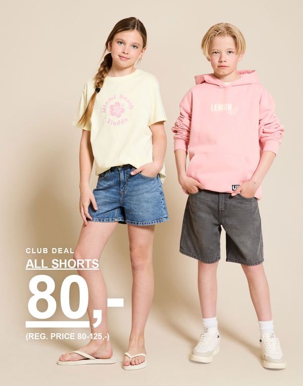 To børn i sommerlige outfits med denimshorts, gul t-shirt og lyserød hættetrøje står foran en lys baggrund. CLUB DEAL ALL SHORTS 80,- (REG. PRICE 80-125,-)