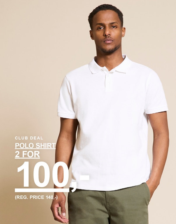 Mand i hvid poloshirt og grønne bukser mod en lys baggrund. CLUB DEAL. POLOSHIRT 2 FOR 100,- (FØRPRIS 140,-)