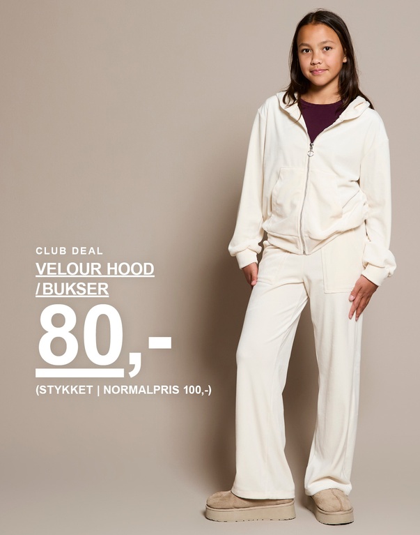 Pige i hvidt velour-sæt med hoodie og vide bukser. Kampagnetekst: 'VELOUR HOOD/BUKSER 80,- PR. DEL (NORMALPRIS 100,-)'.