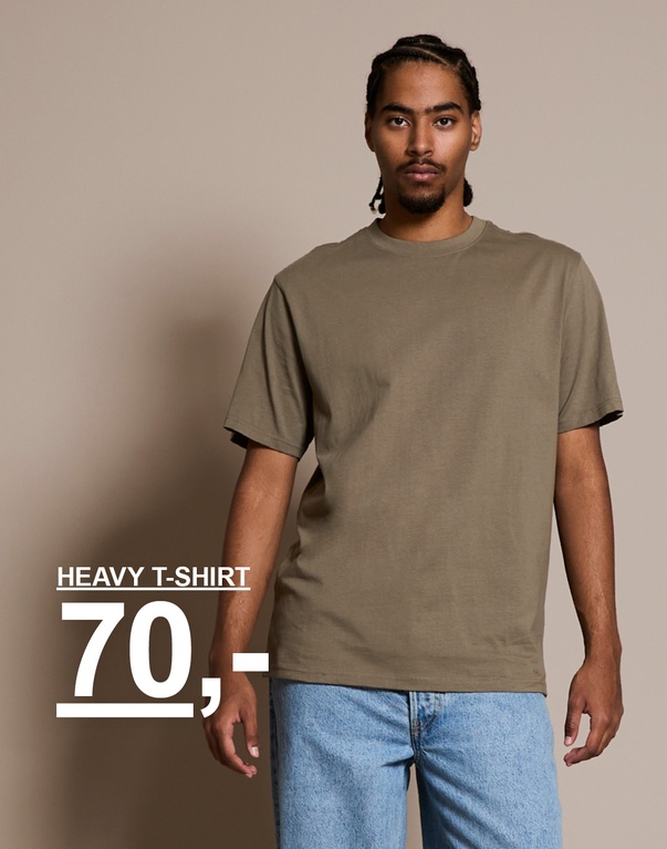 Fyr i olivengrøn t-shirt og lyse jeans. Kampagnetekst: "HEAVY T-SHIRT 70,-"