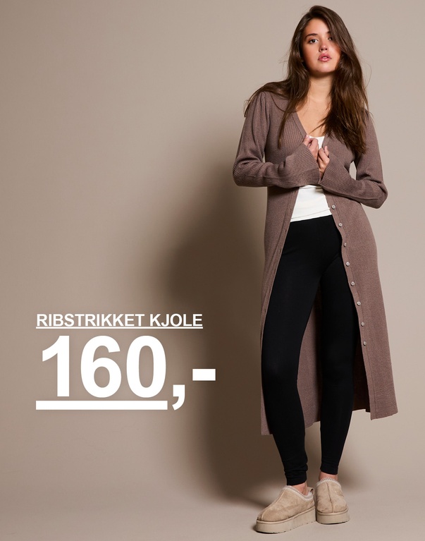 Kvinde i en lang ribstrikket kjole i brun med sorte leggings og beige hjemmesko. Kampagnetekst: "RIBSTRIKKET KJOLE 160,-"