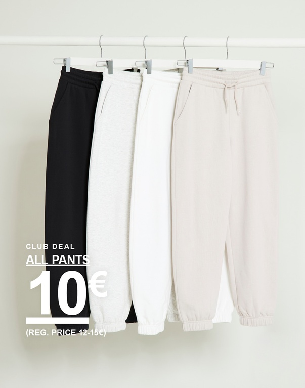 Lasten housuja roikkuu vaatetangossa mustana, vaaleanharmaana, valkoisena ja beigenä vaaleaa taustaa vasten. Kampanjateksti: ”CLUB DEAL ALL PANTS 10€ (REG. PRICE 12–15€)”.