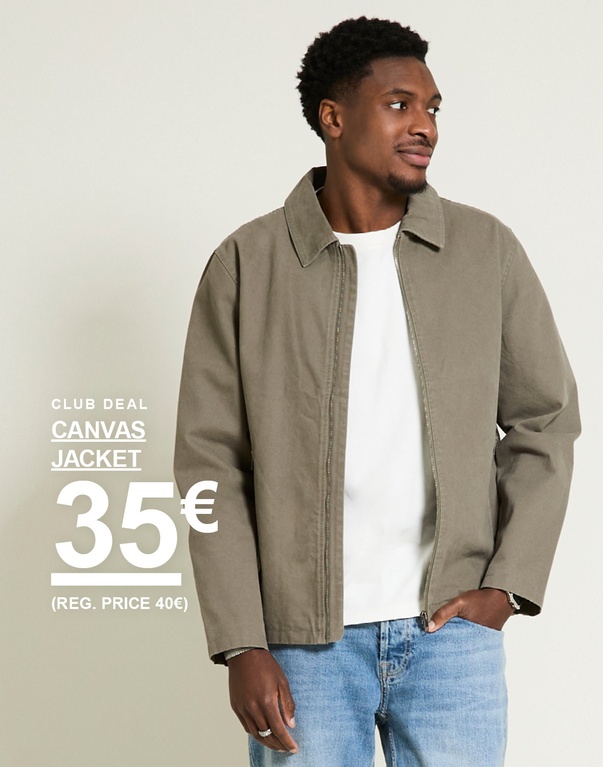 Mies oliivinvihreässä canvas jacket -takissa, valkoinen t-paita ja vaaleat farkut vaaleaa taustaa vasten. Club deal canvas jacket 35€ (reg. price 40€)