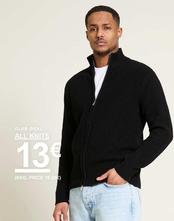 Mies mustassa ribbineulotussa vetoketjullisessa neuletakissa ja vaaleissa farkuissa vaaleaa taustaa vasten. Club deal all knits 13€ (reg. price 15-20€)