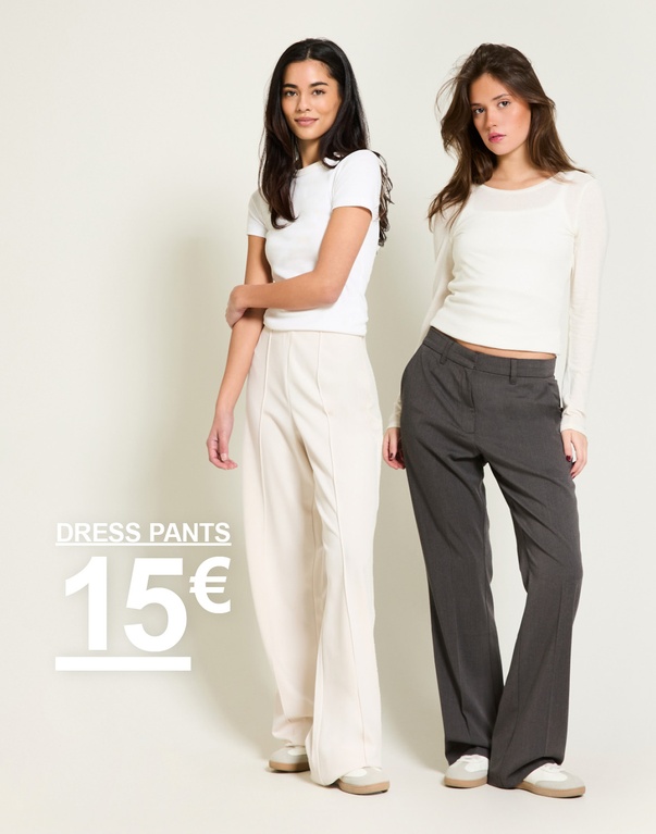Kaksi tyttöä suorahousuissa, yhdet beige ja yhdet tummanharmaat. Kampanjateksti: 'DRESS PANTS, 15€'.