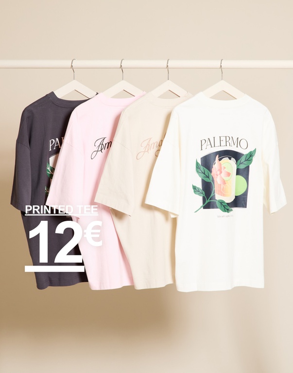 Vier bedruckte T-Shirts in Dunkelgrau, Rosa, Beige und Weiß auf Kleiderbügeln vor beigem Hintergrund. PRINTED TEE 12€