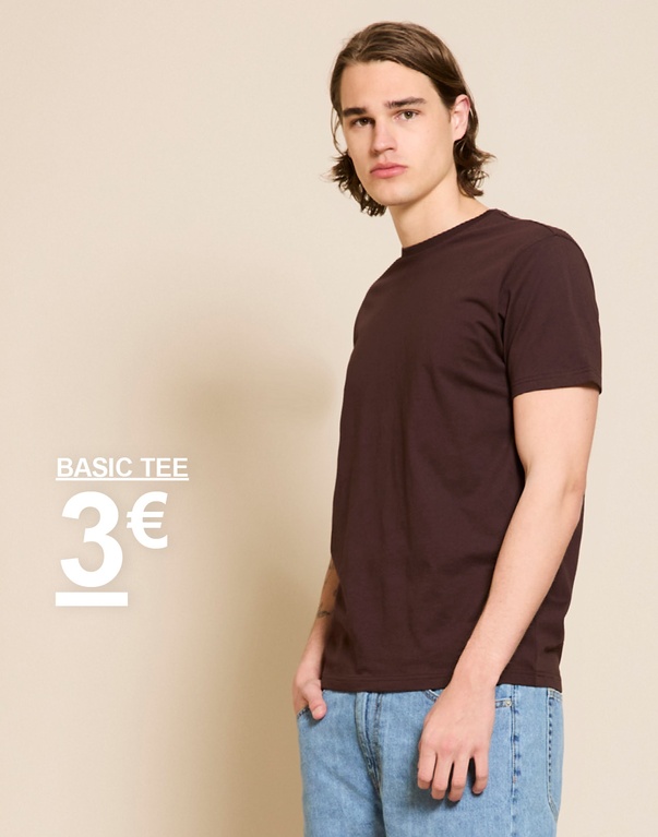 Malli tummanruskeassa basic-t-paidassa ja vaaleissa farkuissa beigeä taustaa vasten. BASIC TEE 3€