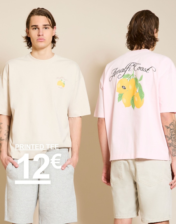 Twee mannen in oversized printed T-shirts – beige en lichtroze met citroenmotief en “Amalfi Coast”-print voor een beige achtergrond. PRINTED TEE 12€
