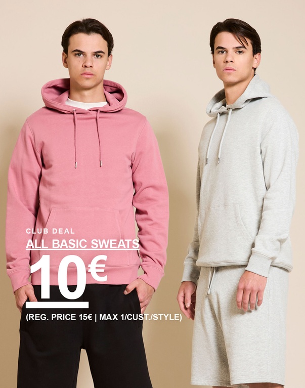 Twee mannen in hoodies en sweatshorts – een roze hoodie met zwarte shorts en een grijze hoodie met bijpassende shorts voor een beige achtergrond. CLUB DEAL. ALL BASIC SWEATS 10€ (REG. PRICE 15€ | MAX 1/CUST./STYLE)