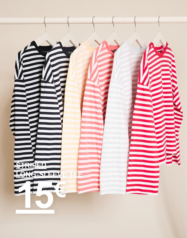 Gestreifte Langarmshirts in Schwarz/Weiß, Dunkelblau, Beige, Rosa, Weiß und Pink auf Kleiderbügeln. Kampagnentext: „STRIPED LONG SLEEVE TEE, 15€“.