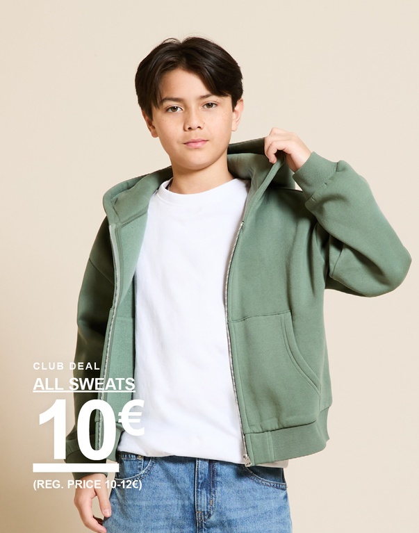 Junge vor hellem Hintergrund in grünem Kapuzen-Sweatshirt mit Reißverschluss, weißem T-Shirt und Jeans. CLUB DEAL ALL SWEATS 10€ (REG. PRICE 10-12€)