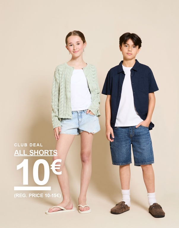 Ein Mädchen und ein Junge stehen vor hellem Hintergrund und tragen Jeansshorts, weißes T-Shirt, hellgrüne Strickjacke und dunkelblaues Hemd. CLUB DEAL ALL SHORTS 10€ (REG. PRICE 10-15€)