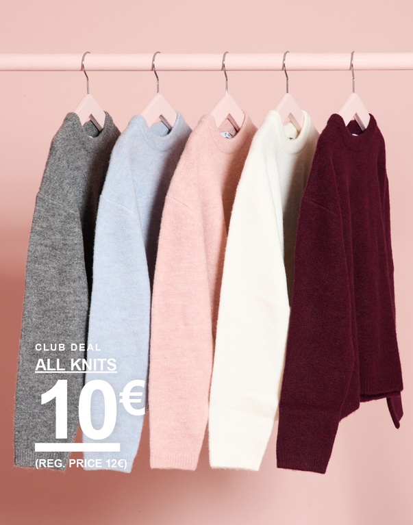 Strickpullover in Grau, Hellblau, Rosa, Weiß und Bordeauxrot hängen an einer Kleiderstange. CLUB DEAL – ALL KNITS 10€ (regulärer Preis 12€).