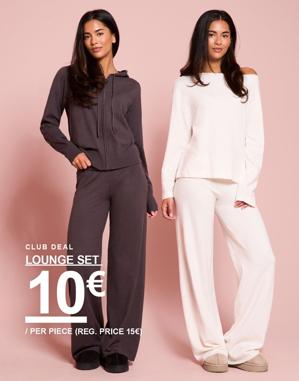 Drie meiden in loungesets in donkerbruin, offwhite en beige. Campagnetekst: ‘LOUNGE SET, 10€/STUK (VAN 15€)’.
