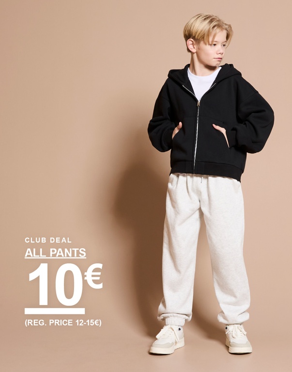 Lapsi mustassa hupparissa ja vaaleanharmaissa collegehousuissa seisoo vaaleaa taustaa vasten. Teksti: ”Club deal”, ”All pants 10 € (reg. price 12–15 €)”.