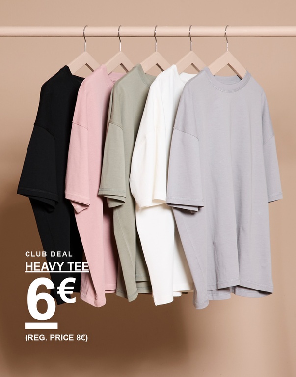 Viisi yksiväristä heavy tee -t-paitaa mustana, vaaleanpunaisena, vihreänä, valkoisena ja harmaana henkarissa beigen taustan edessä. Kampanjateksti: “CLUB DEAL HEAVY TEE 6€ (REG. PRICE 8€)”.