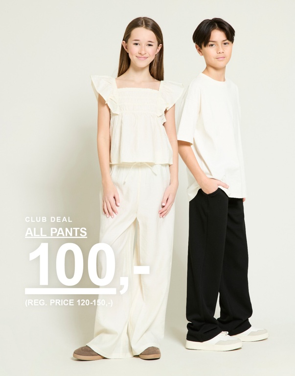 To barn i lyse topper og bukser i beige og svart. Kampanjetekst: «ALL PANTS, 100,-»