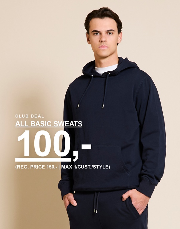 Mann i mørkeblå hoodie og sweatpants foran beige bakgrunn. CLUB DEAL. ALL BASIC SWEATS 100,- (REG. PRICE 150,- | MAX 1/CUST./STYLE)