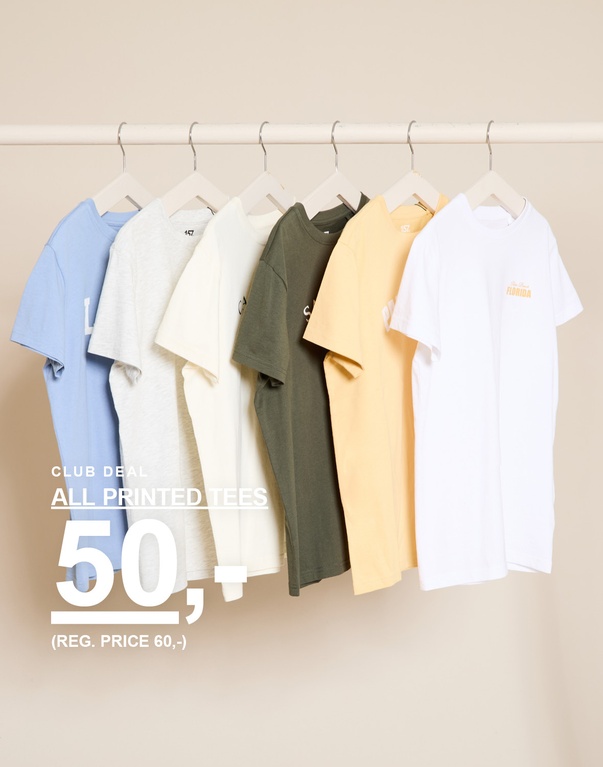 Seks printede t-skjorter i fargene blå, grå, hvit, grønn, gul og hvit på hengere foran en lys bakgrunn. CLUB DEAL ALL PRINTED TEES 50,- (REG. PRICE 60,-)