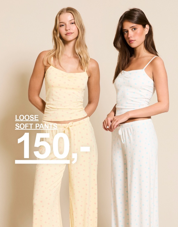 To jenter i loose soft pants med blomstermønster, ett sett i lysegul og ett sett i hvit med lyseblå blomster. Kampanjetekst: "LOOSE SOFT PANTS, 150,-".