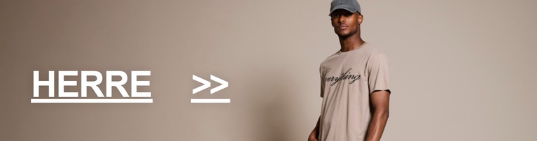 Gutt i beige printed t-shirt och ljusa jeans. Kategoriknapp med teksten "HERRE >>".