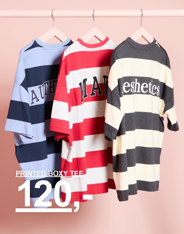 Tre stripete printed boxy t-skjorter på kleshengere i lyseblått/mørkeblått, rødt/hvitt og mørkegrått/offwhite. Kampanjetekst: "PRINTED BOXY TEE 120,-"